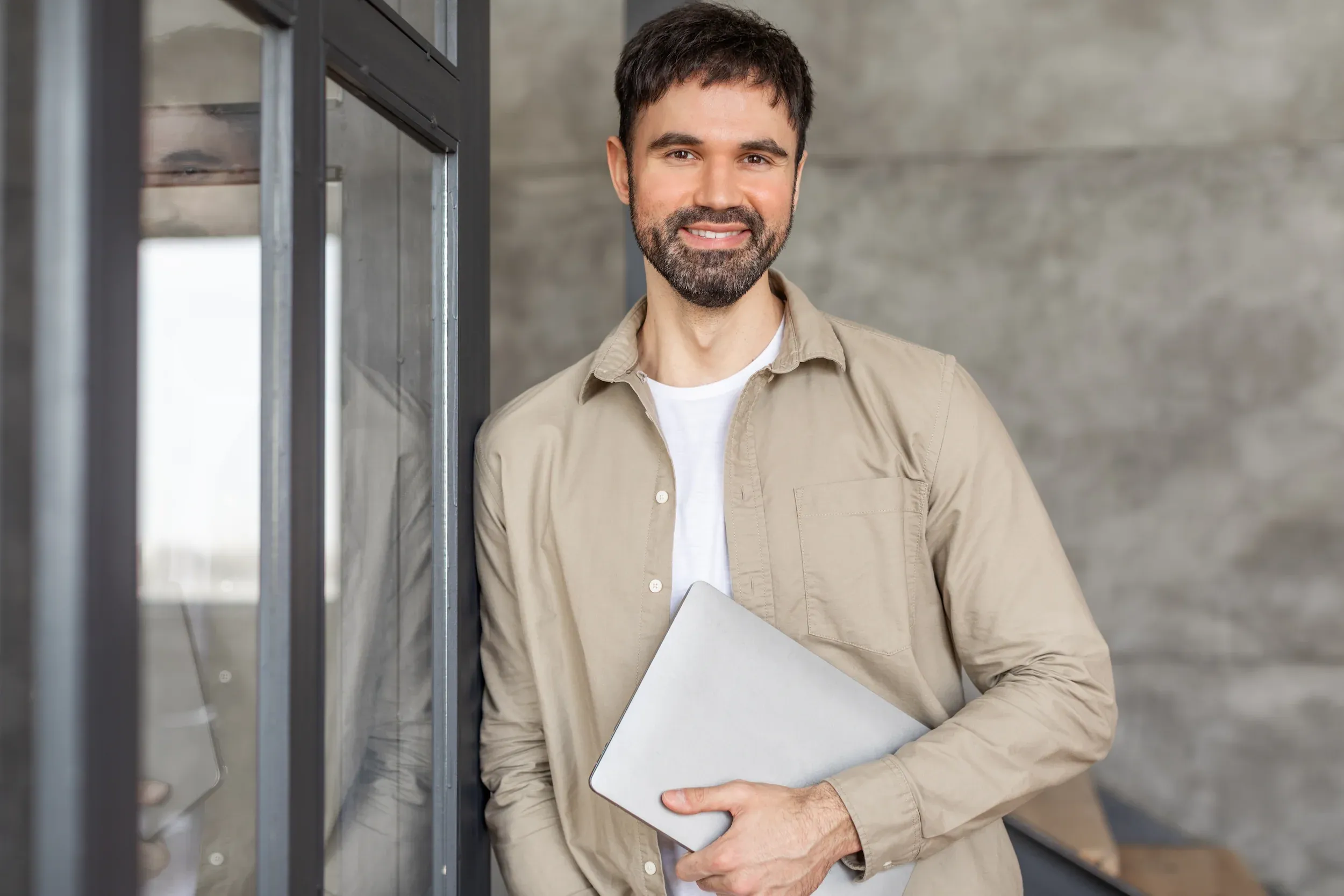 Confident man with healthy hair in modern office setting - hair restoration treatment outcomes at ANU Face Mind Body