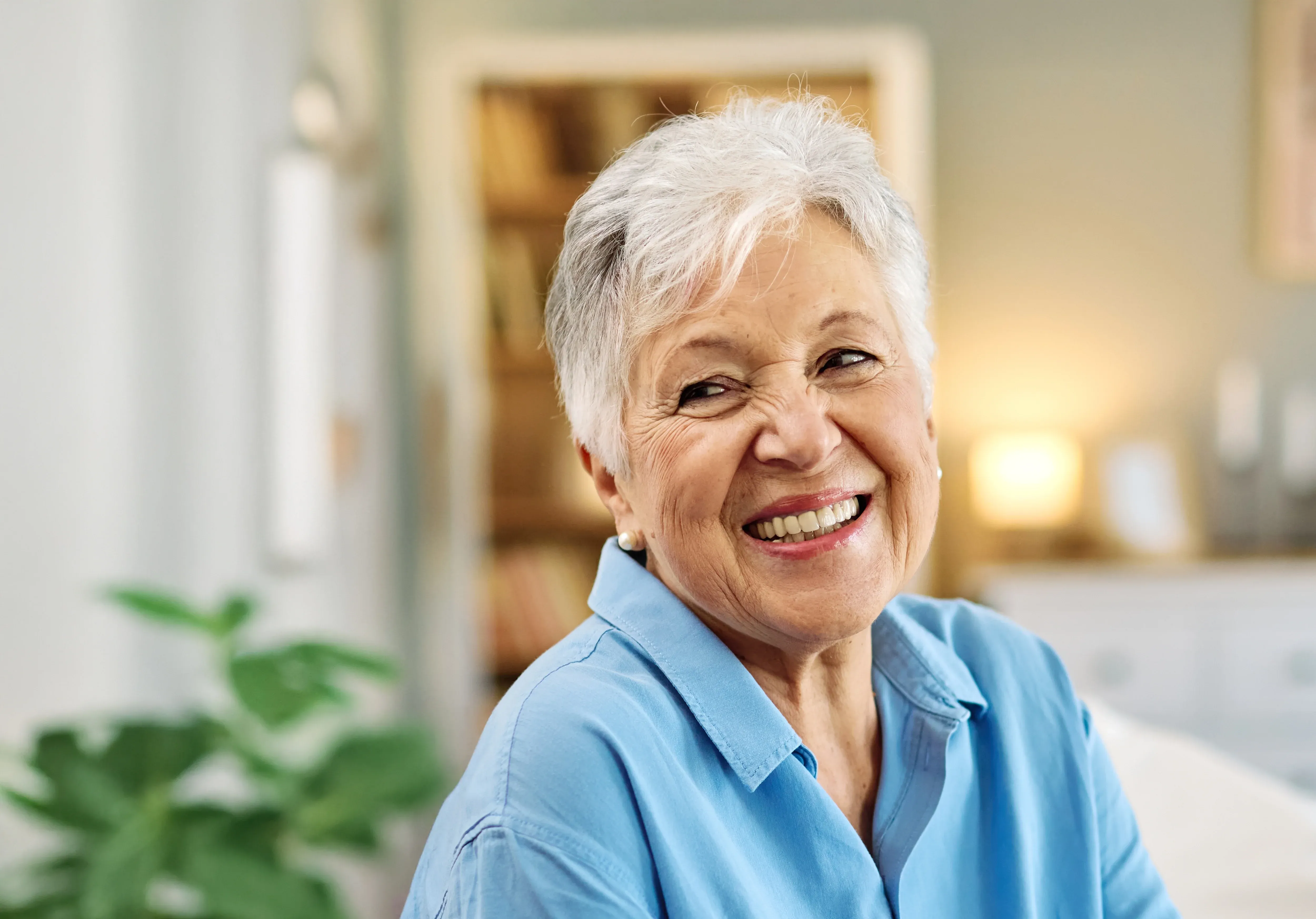 Mature woman with natural smile lines and silver hair laughing - understanding causes of wrinkles and aging skin