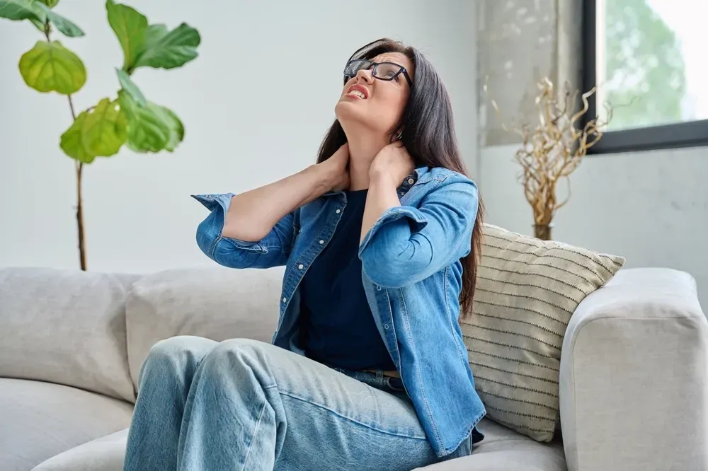 Person concerned about persistent back pain at Arise Integrative Wellness