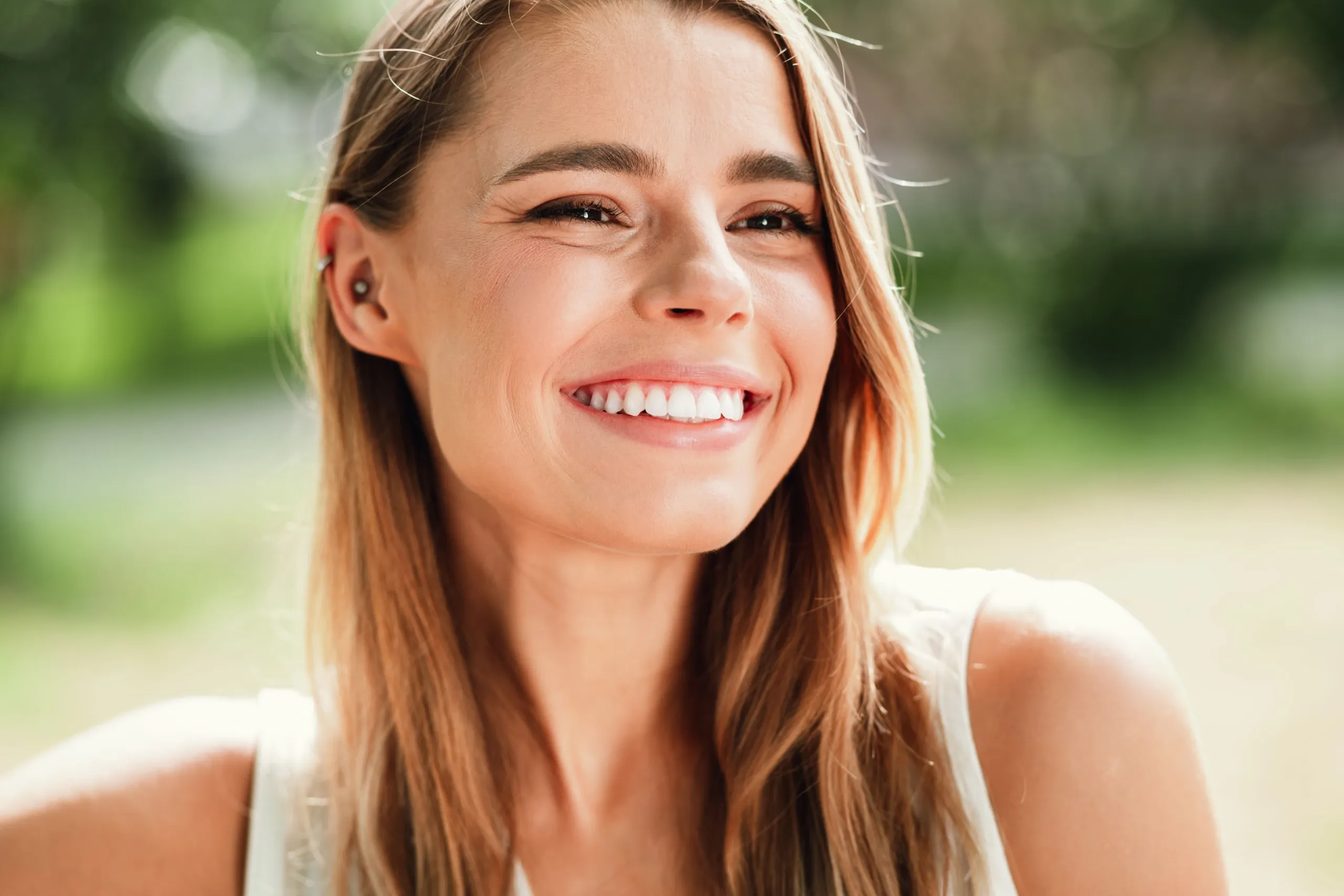 Happy young woman smiling outdoors representing health and wellness at Bensa Chiropractic Bradenton