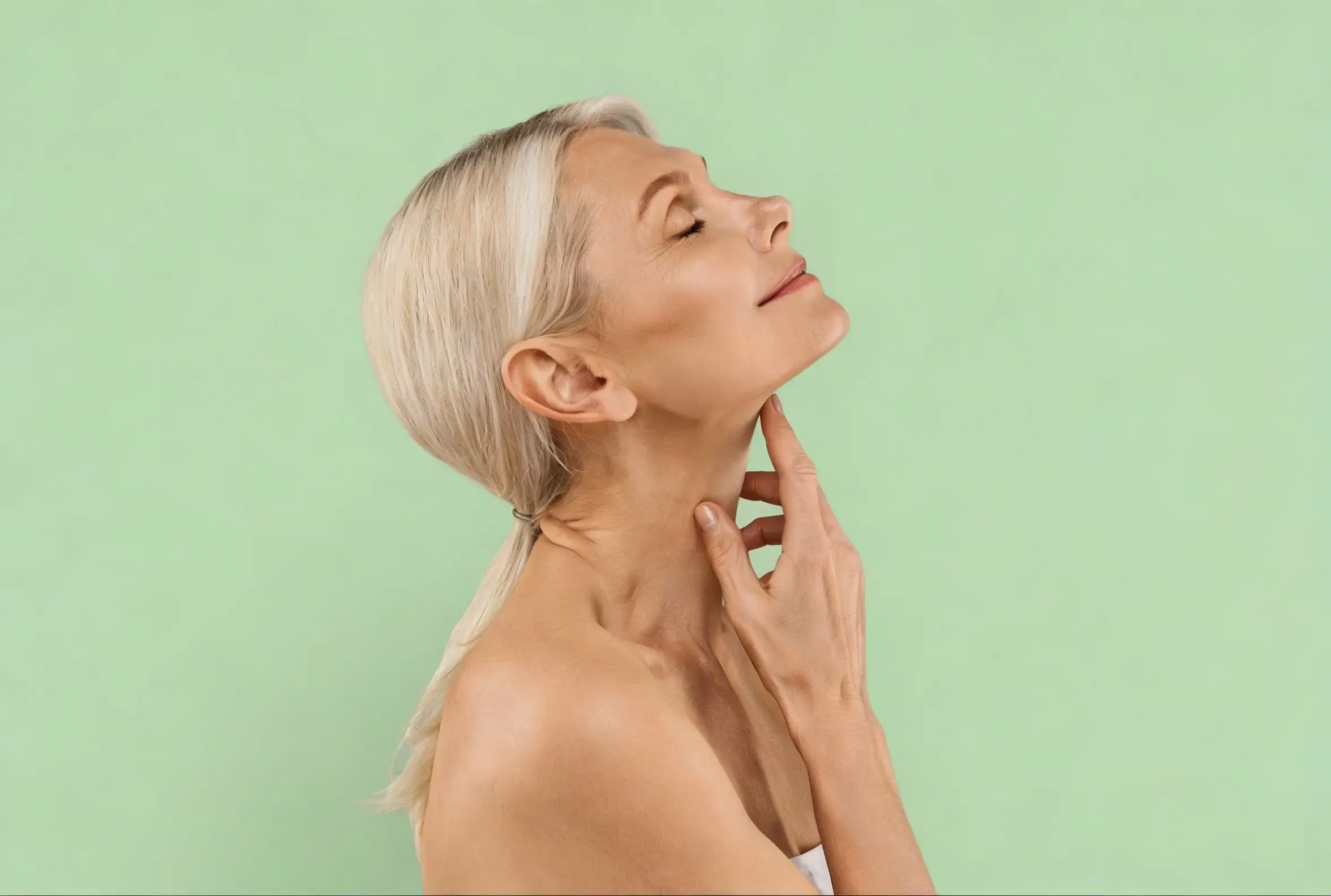 Woman examining loose skin on her jawline at Hartley Health and Wellness Canton