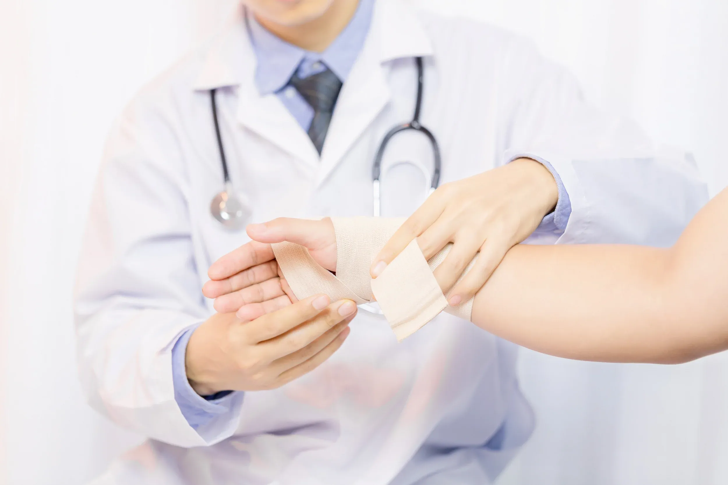 Orthopedic provider examining a post-surgical wound dressing in Fort Walton Beach, FL