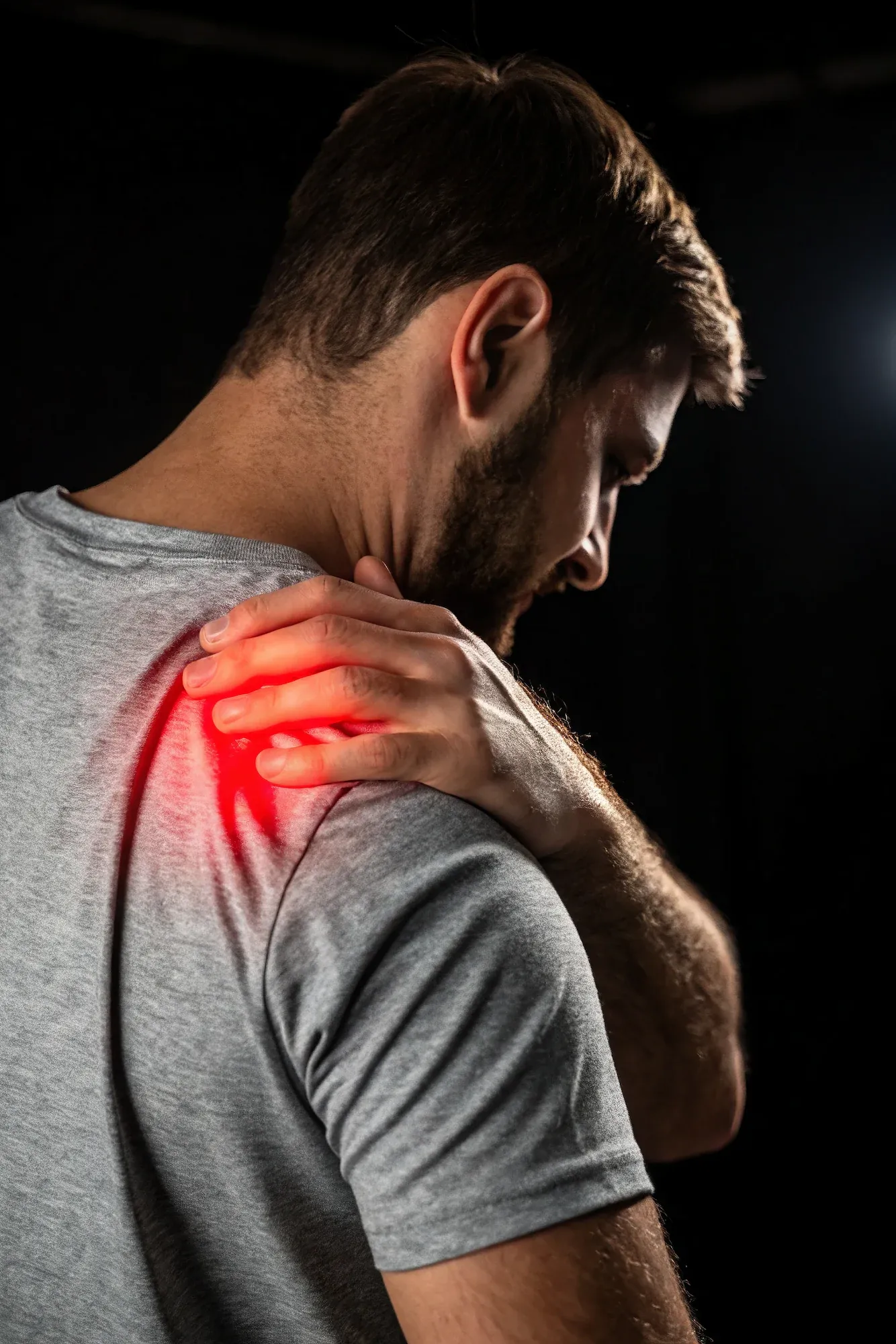 Patient demonstrating shoulder pain symptoms at Roots Chiropractic and Wellness Alma