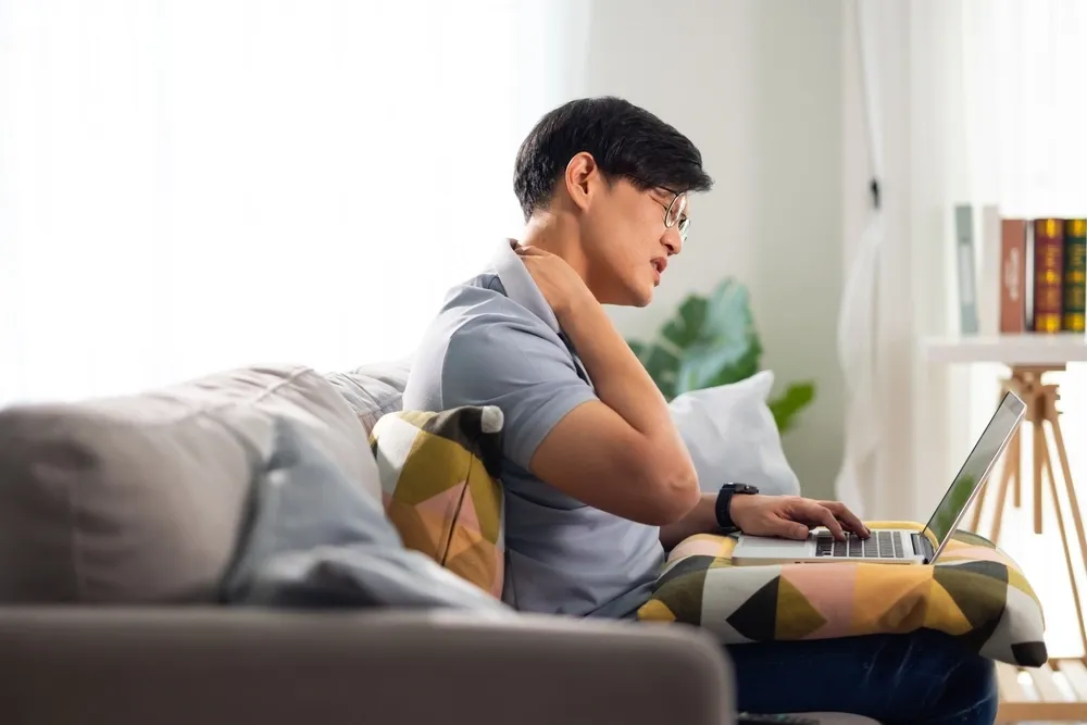 Person concerned about neck pain at Roots Chiropractic and Wellness
