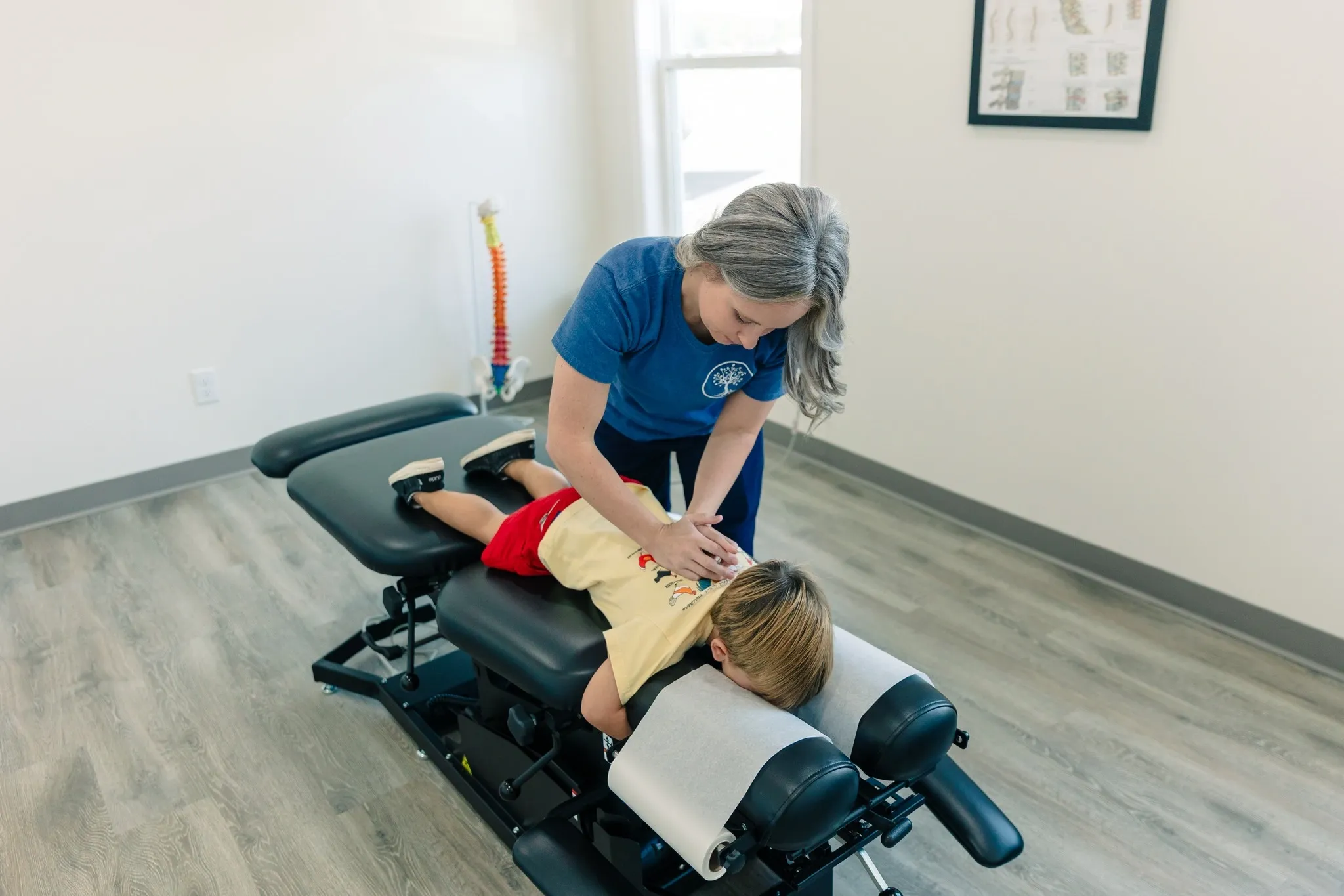 Chiropractor performing a gentle adjustment on a child in Alma, GA