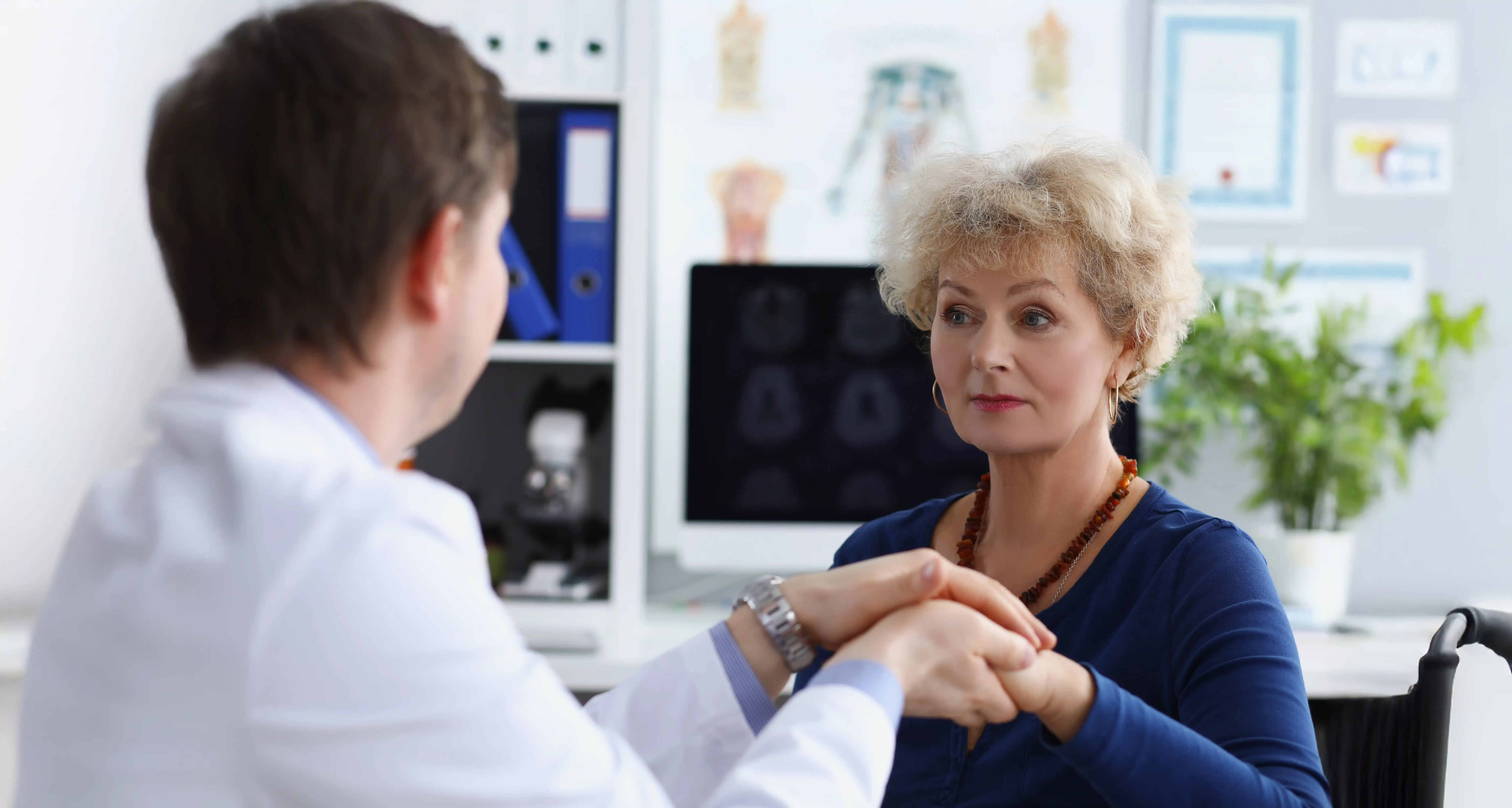 Person holding their lower back in discomfort from kidney stone pain, cared for in Jacksonville, FL.