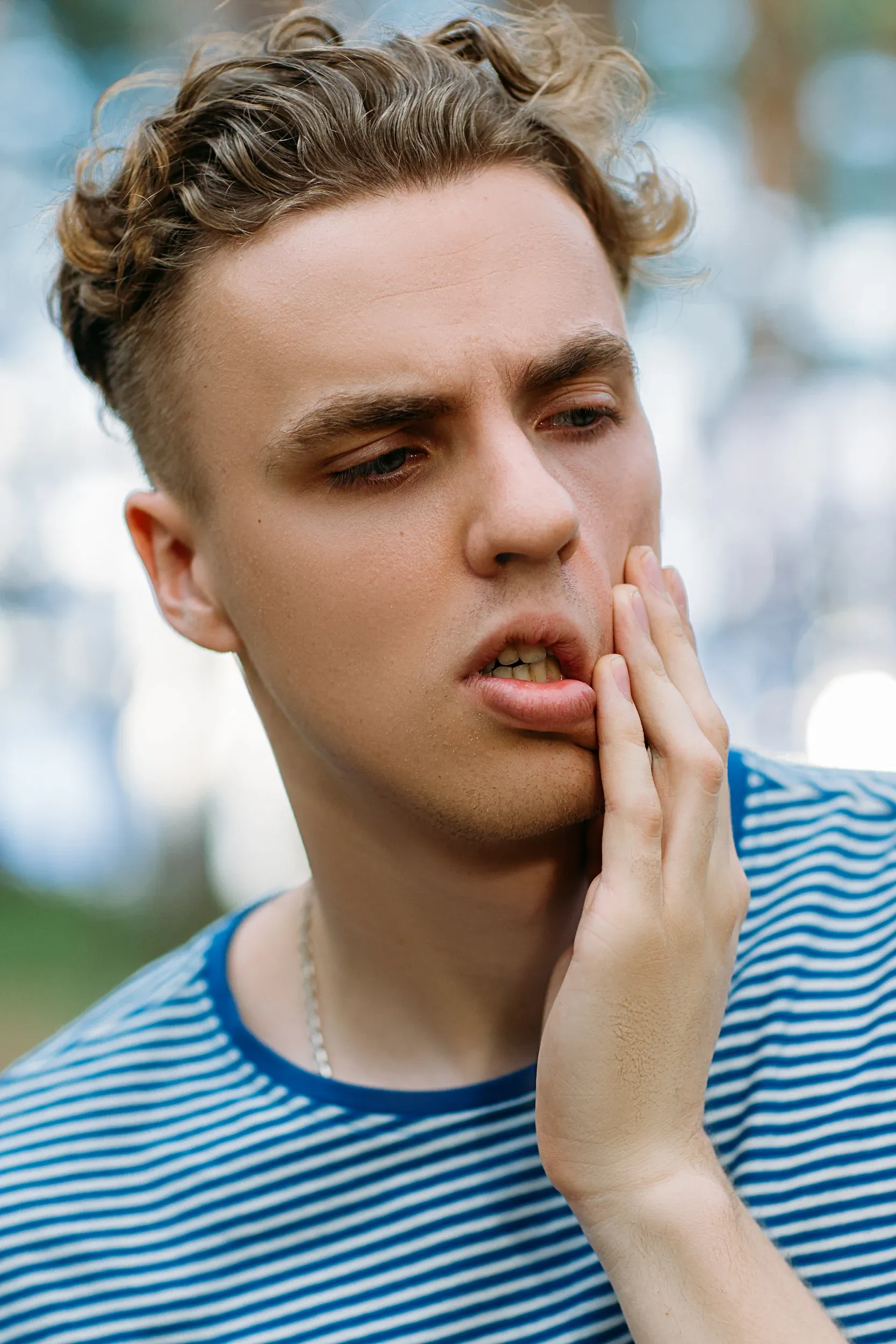 Person concerned about tooth sensitivity at Dental World Longwood