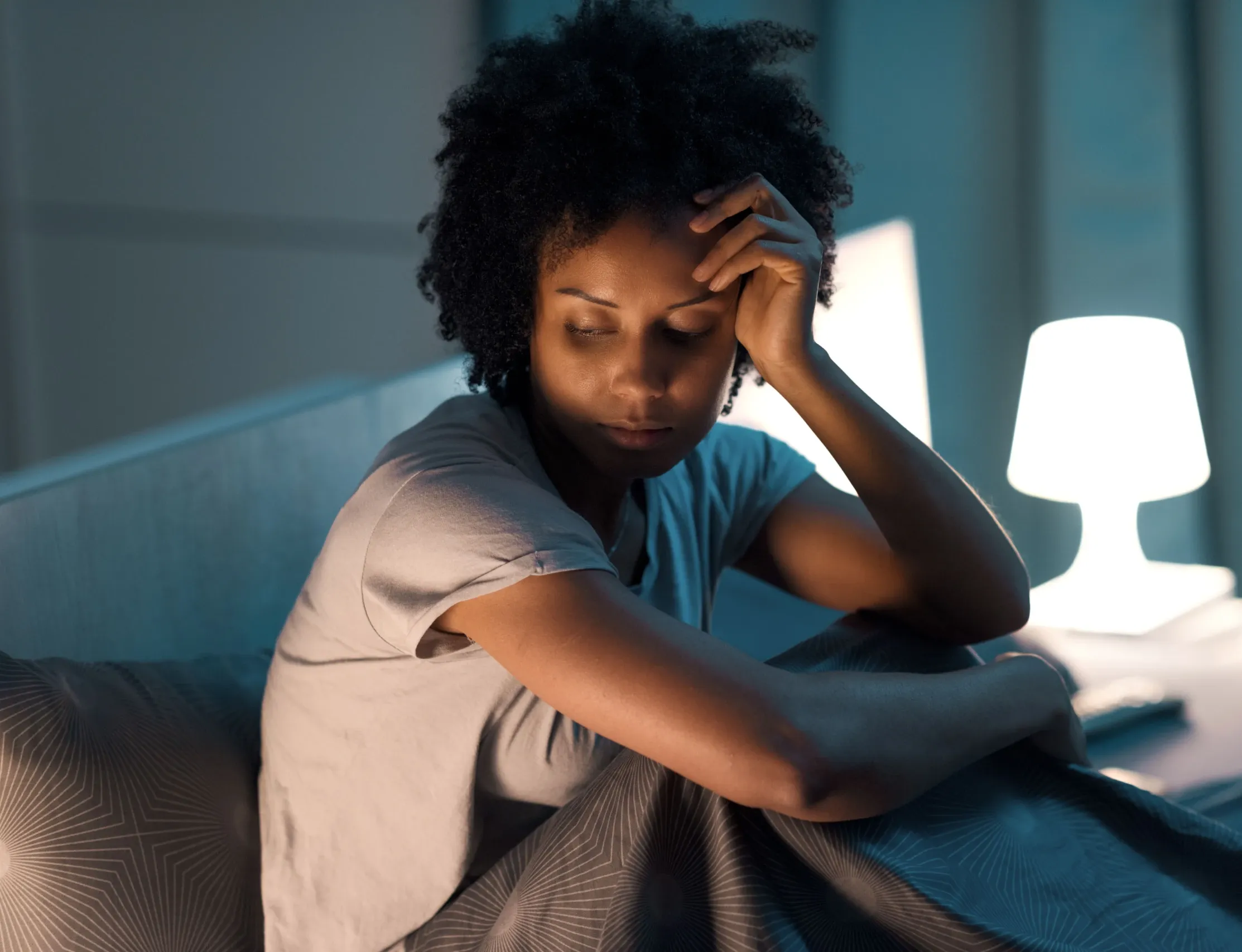 Person struggling with insomnia, staring at ceiling in dark bedroom